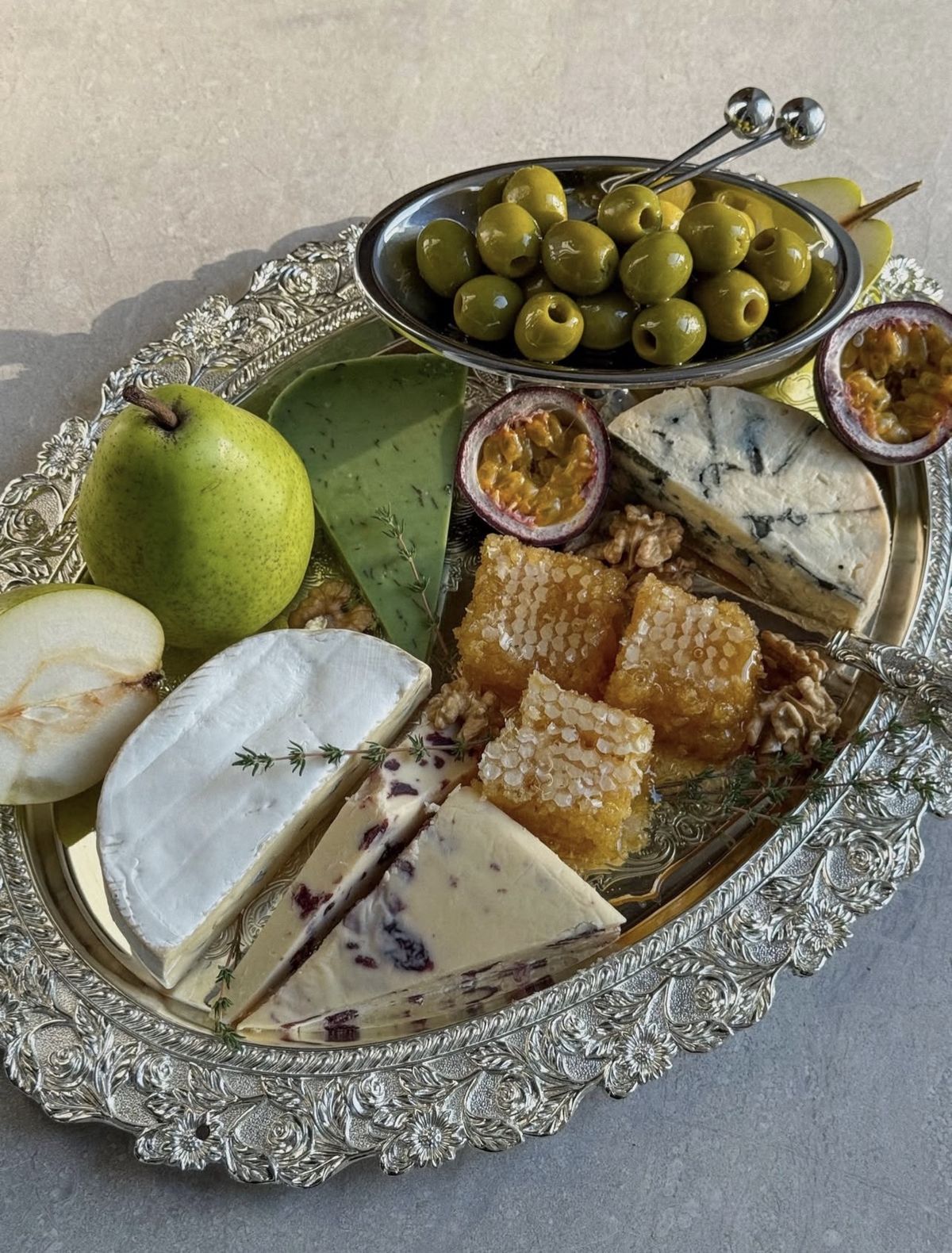 Silver tray with olives, cheese, and honey
